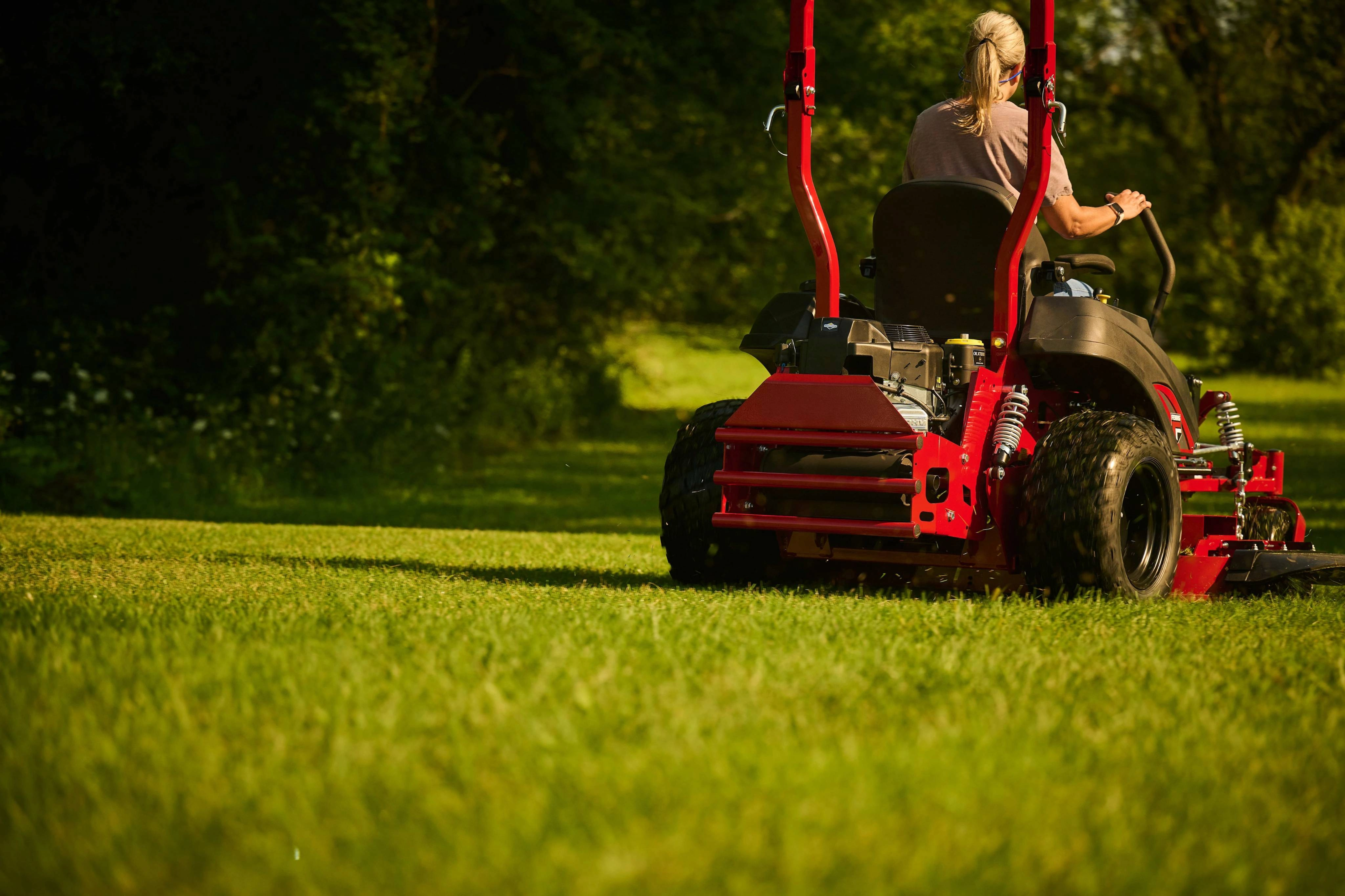 Landscaper driving a Ferris zero-turn riding mower powered by a Briggs & Stratton CXi engine with Oil Xtend